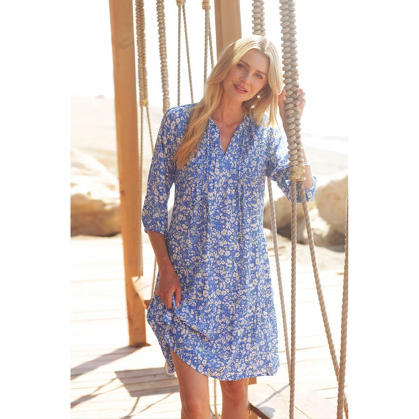 Pomodoro floral tea dress in blue with model stood beside a swing 