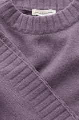 Close-up of a ribbed knit sweater in a muted dusty lavender-purple color, showing the collar and a small white neck label that reads 'SEASALT CORNWALL'.