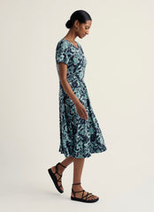 Woman wearing a floral dress on a plain background