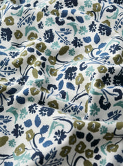 Floral patterned fabric with blue, green, and brown colours on a white background.