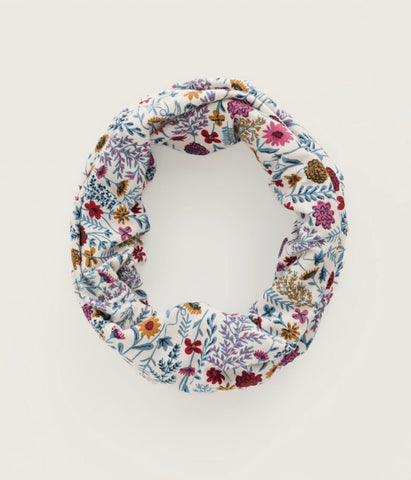 Close up of fabric in floral botanical print, in multicolours red, yellows and blues. 