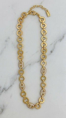Envy Jewellery gold-tone chain necklace with alternating large oval links and smaller oval links set with clear crystals, displayed on a white marble surface.
