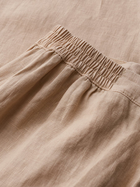 Close-up of beige pants with a focus on the waistband.