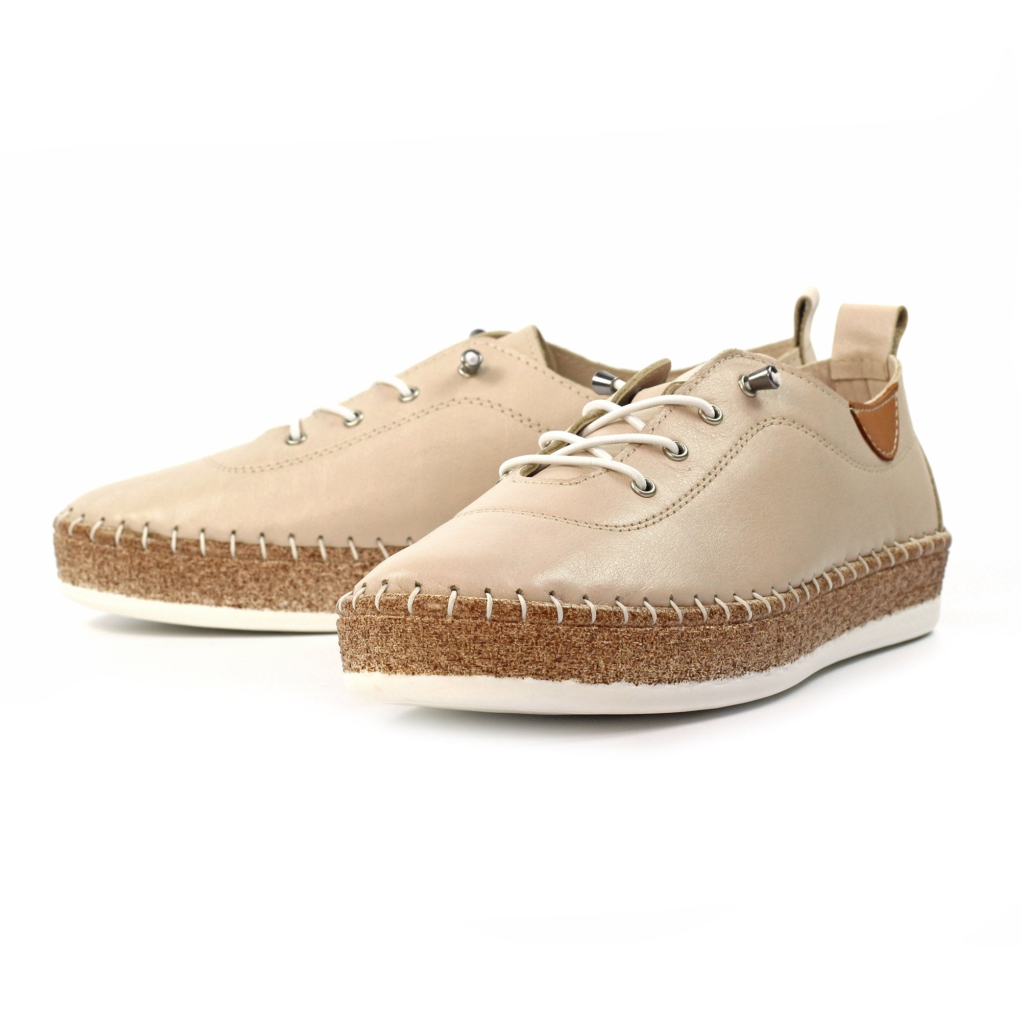 Beige trainers with cork soles on a white background